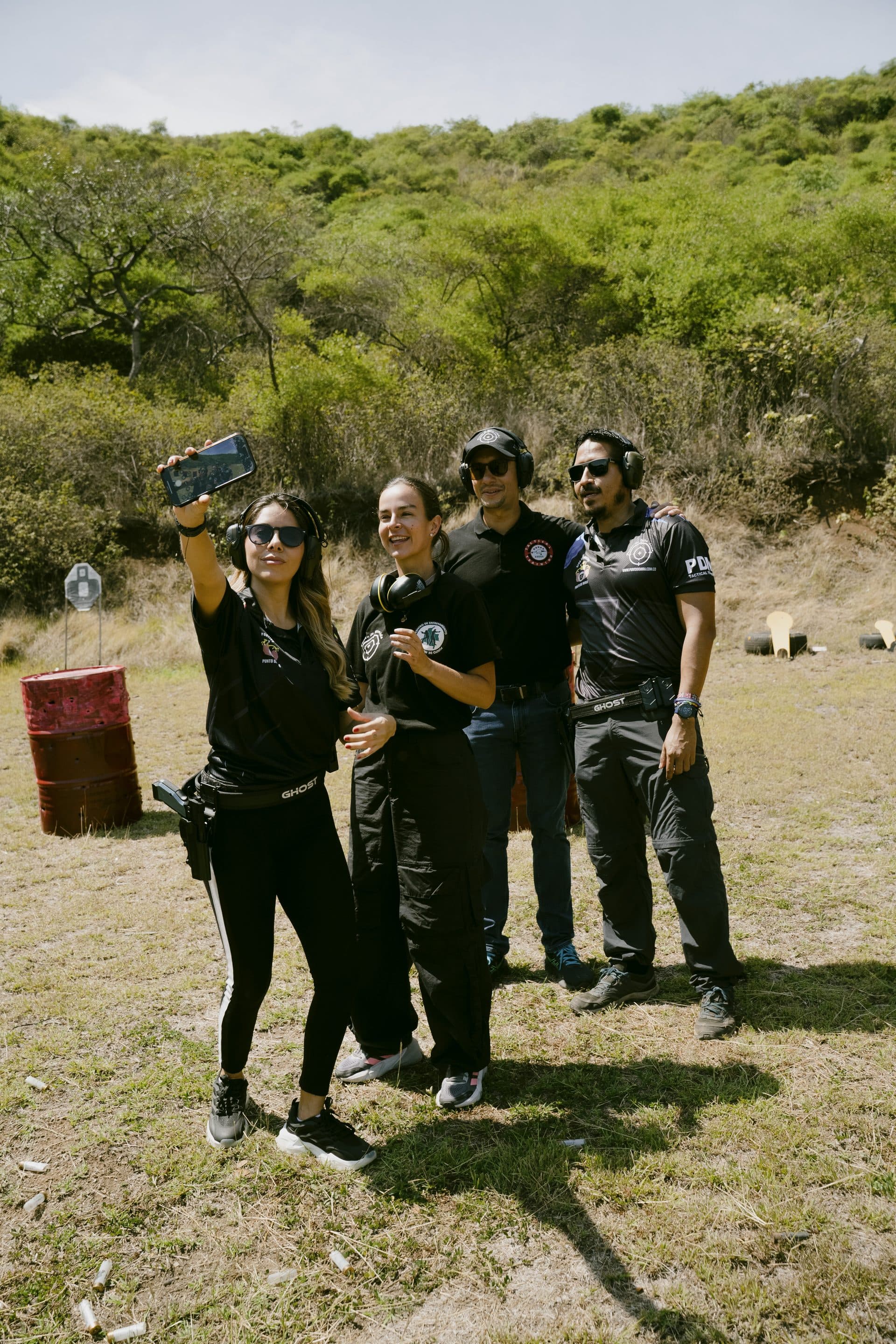 Grupo de participantes tomándose una selfie con los instructores al final de su jornada en el polígono